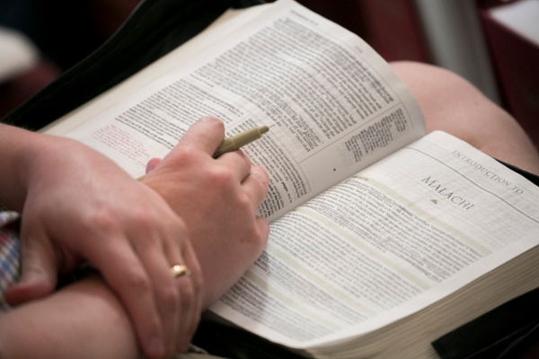 Bible on Lap Open to Malachi