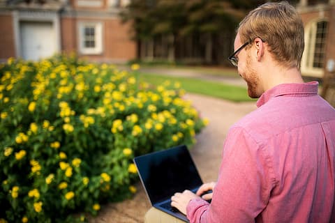 male divinity student with laptop