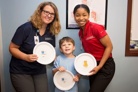 Students and child with artwork