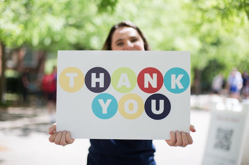 Student holding up a 'Thank You' sign