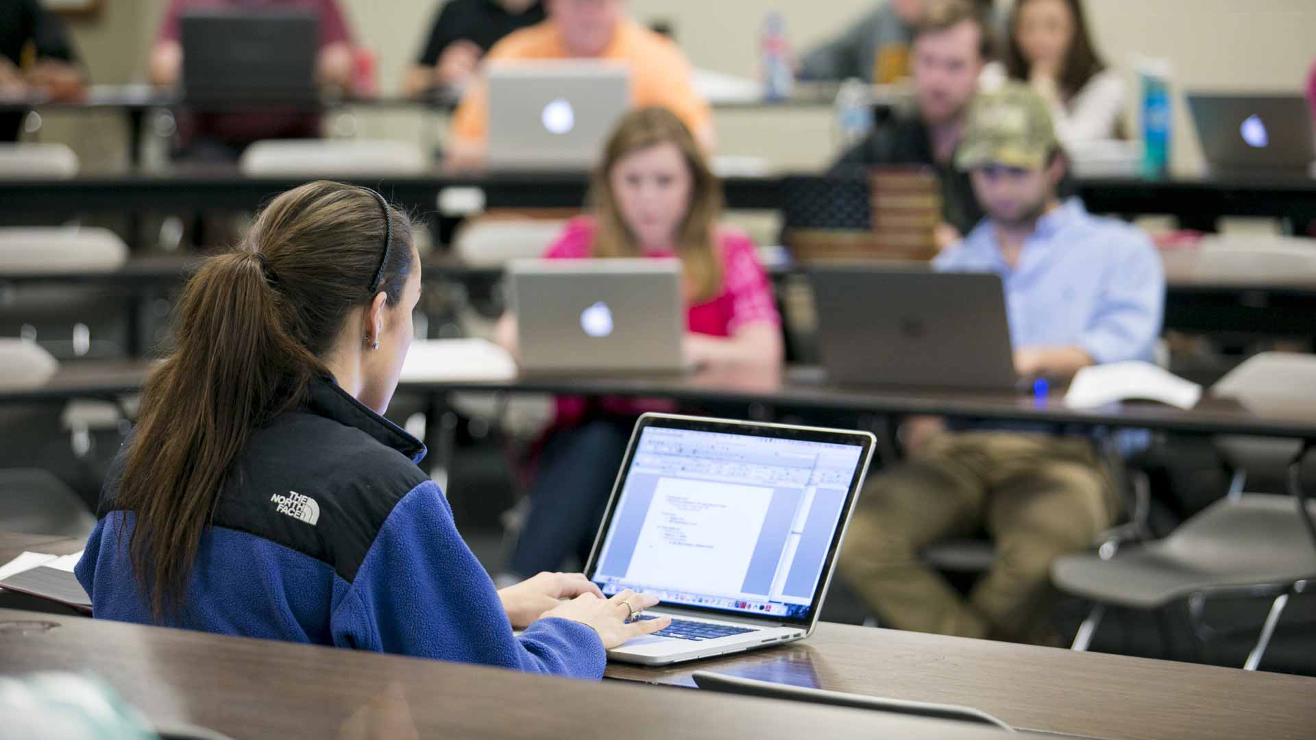 woman typing on keyboard in classroom