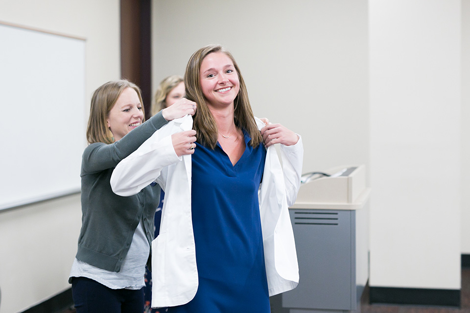 Dietetic intern receives her white coat.